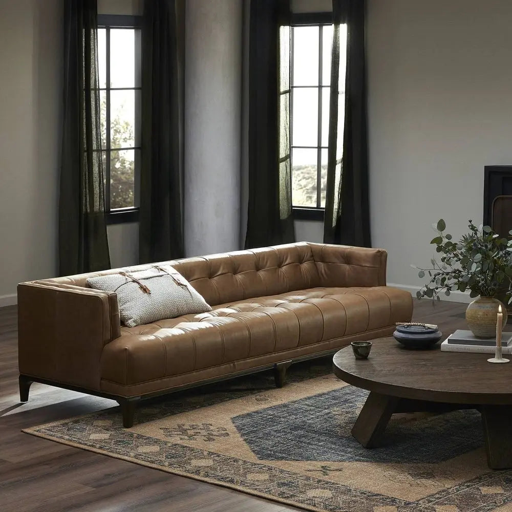 Brown leather sofa in a living room with a wooden coffee table.