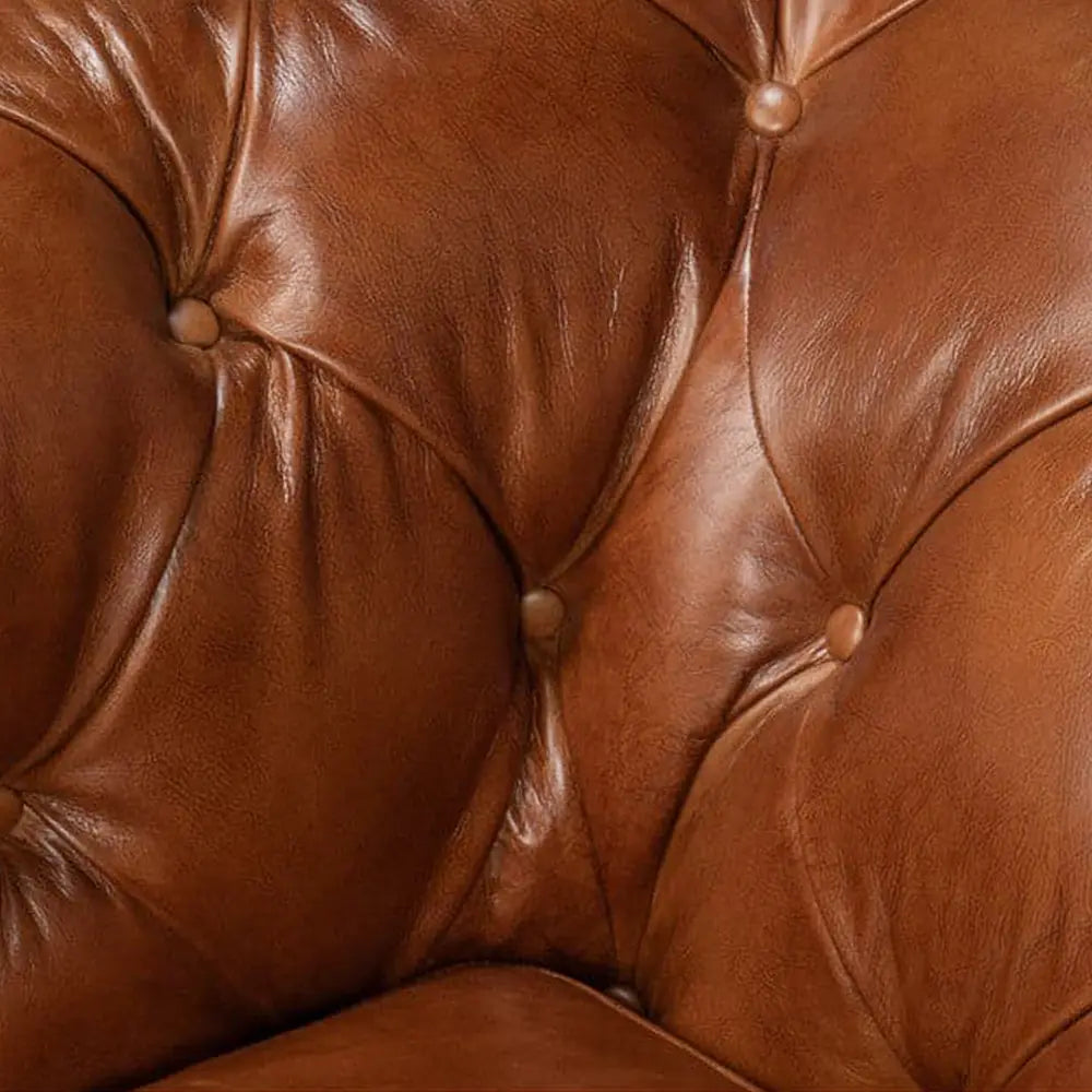 Close-up of a brown leather sofa with tufted backrest