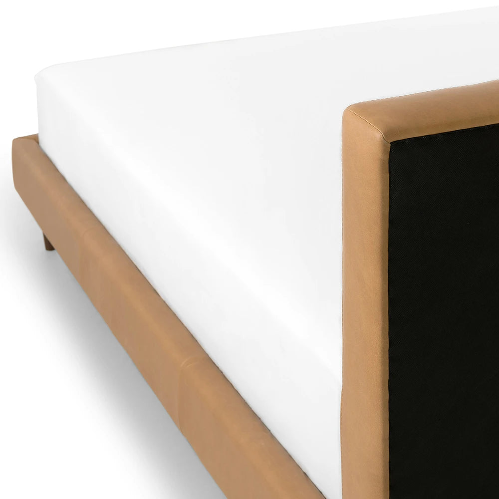 Bed frame with brown leather headboard and white mattress on a white background