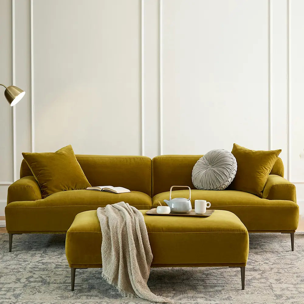 Mustard yellow sectional sofa with cushions and a small table in a living room setting.