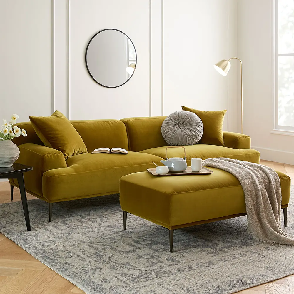 Modern living room with a mustard yellow sectional sofa and matching ottoman.
