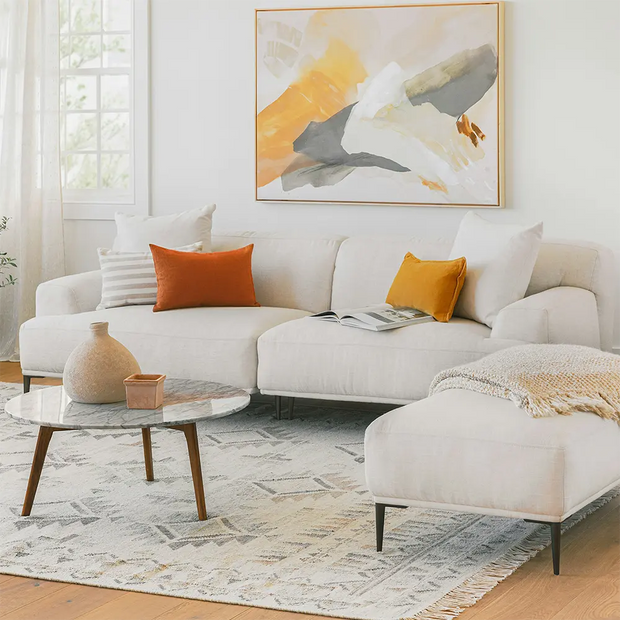 Modern living room with a white sectional sofa and soft pillows.