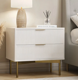 White nightstand with gold legs in a bedroom setting