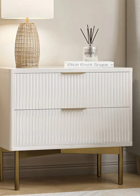 White nightstand with gold legs in a bedroom setting