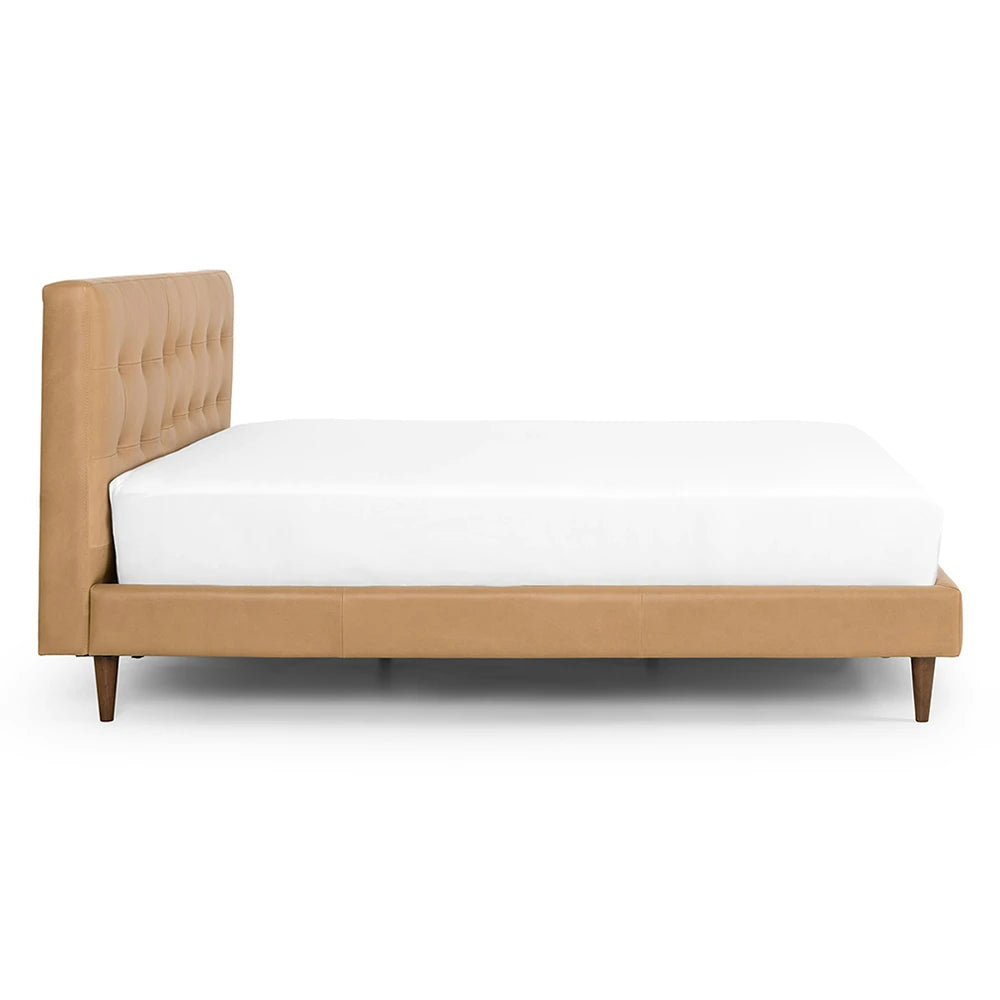 Beige upholstered bed with white mattress on a white background