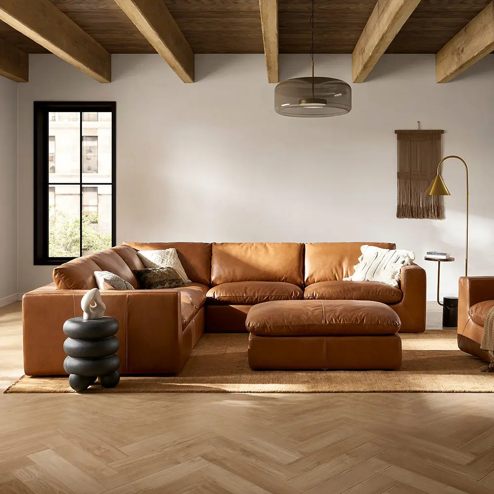 Modern living room with a brown leather sectional sofa and decorative elements.