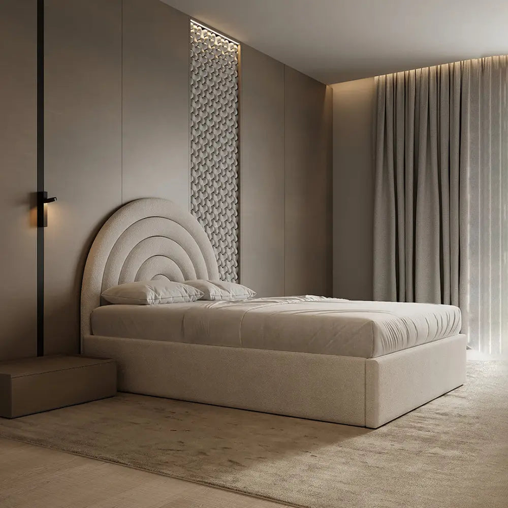 Beige upholstered bed in a modern bedroom with decorative wall and curtains.