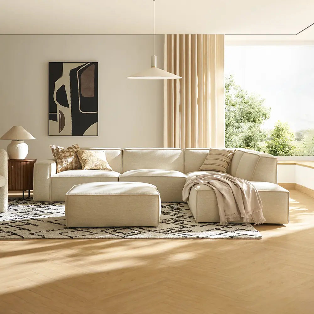 Modern living room with a beige sectional sofa and ottoman.