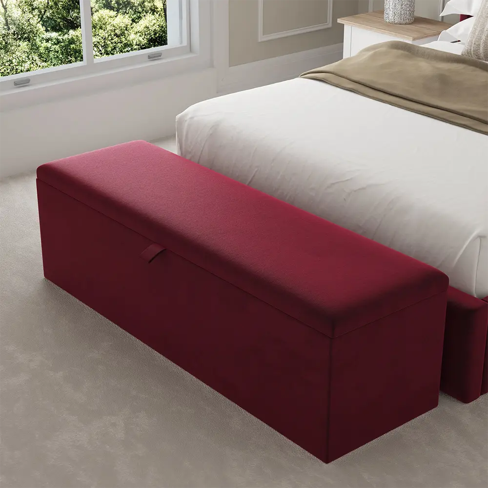 Red storage ottoman in a bedroom setting with a bed adds a refined aesthetic.