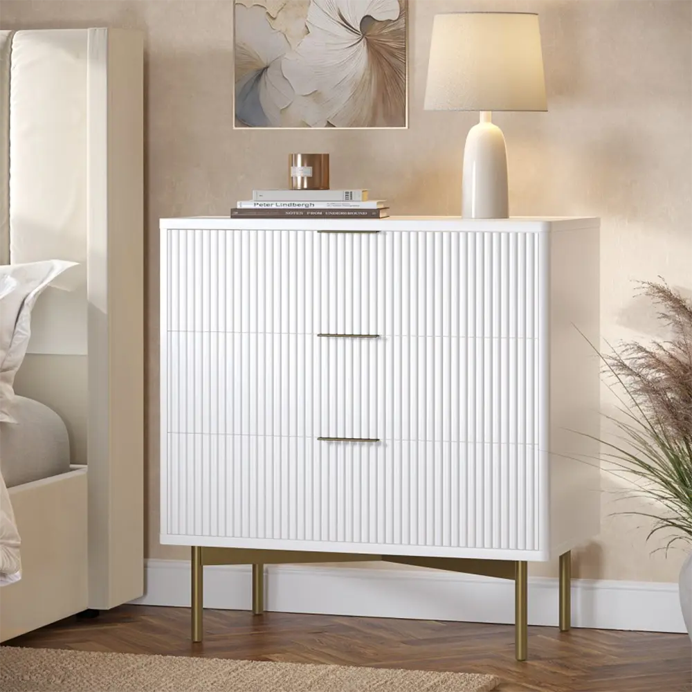 White cabinet with gold legs in a room setting with decor elements.
