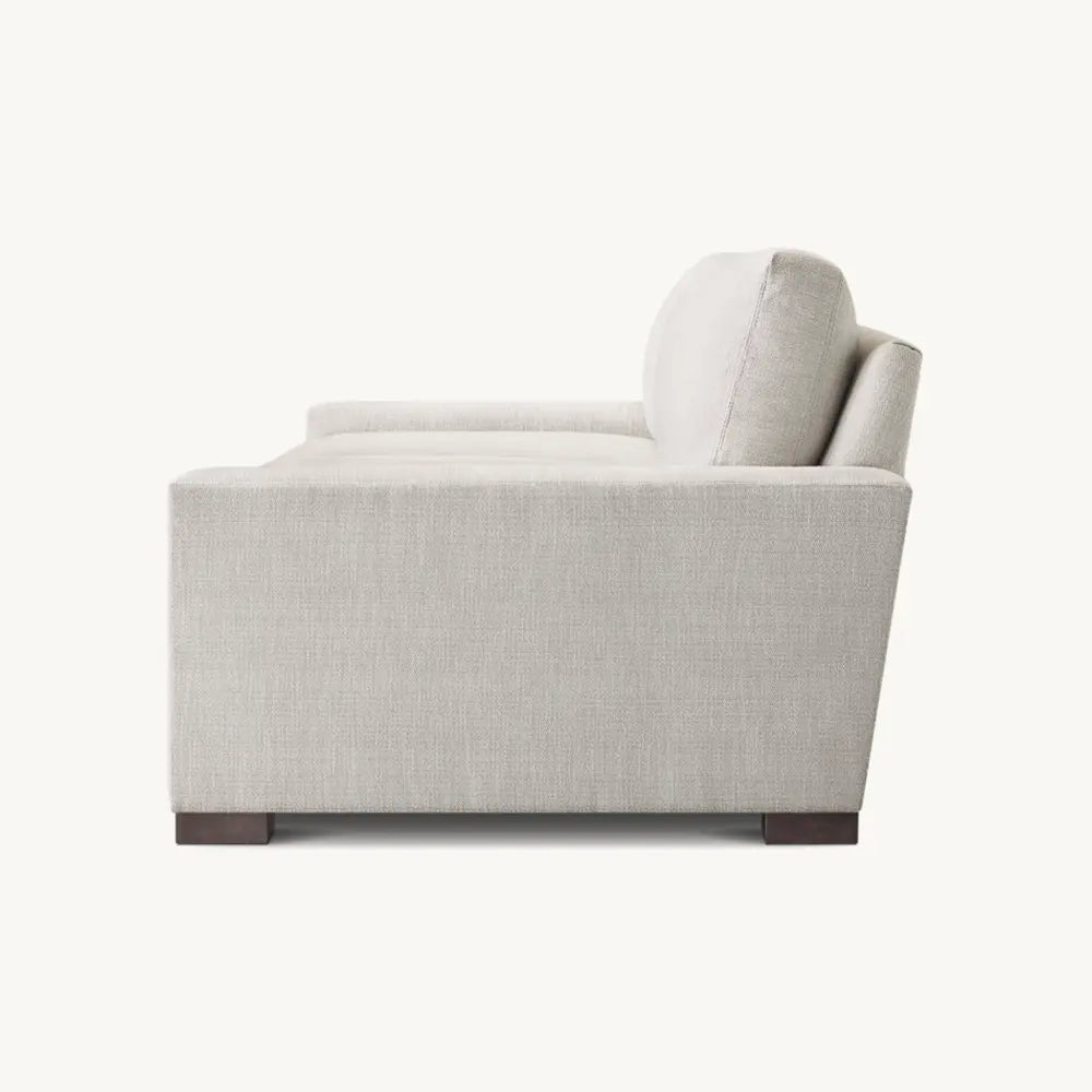 Gray sofa from side angle with sturdy frame in living space setting.