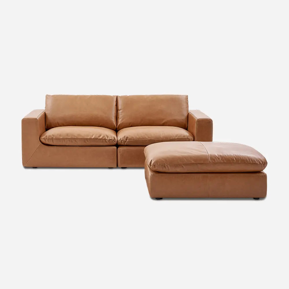 Brown leather sofa with matching ottoman in modern living room.