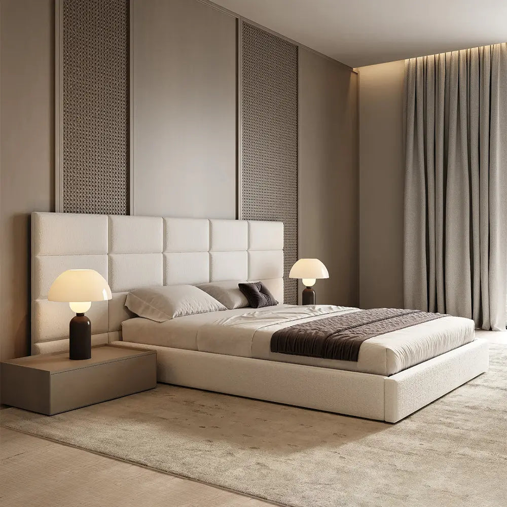 Modern bedroom with a beige upholstered bed and bedside table.