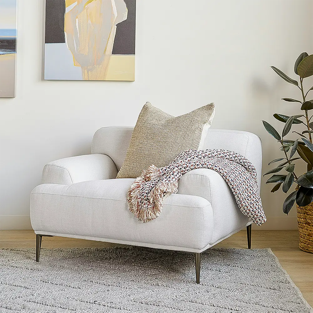 White armchair in a living room setting adds a refined aesthetic.