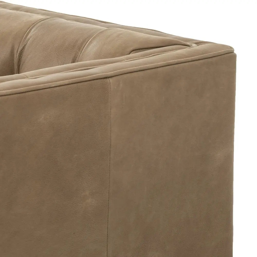 Close-up of a brown leather sofa corner in modern lounge setting.
