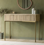 Wooden console table against a green wall with decorative items.