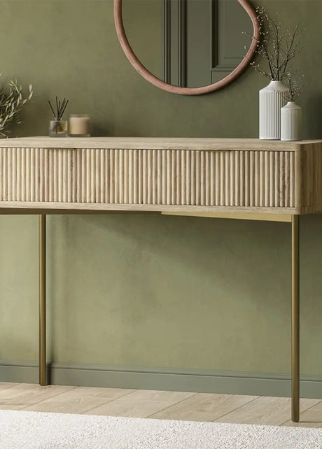 Wooden console table against a green wall with decorative items.