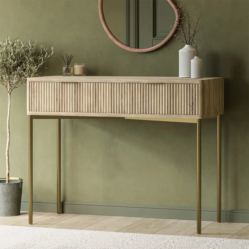 Wooden console table against a green wall with decorative items.