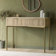 Wooden console table against a green wall with decorative items.