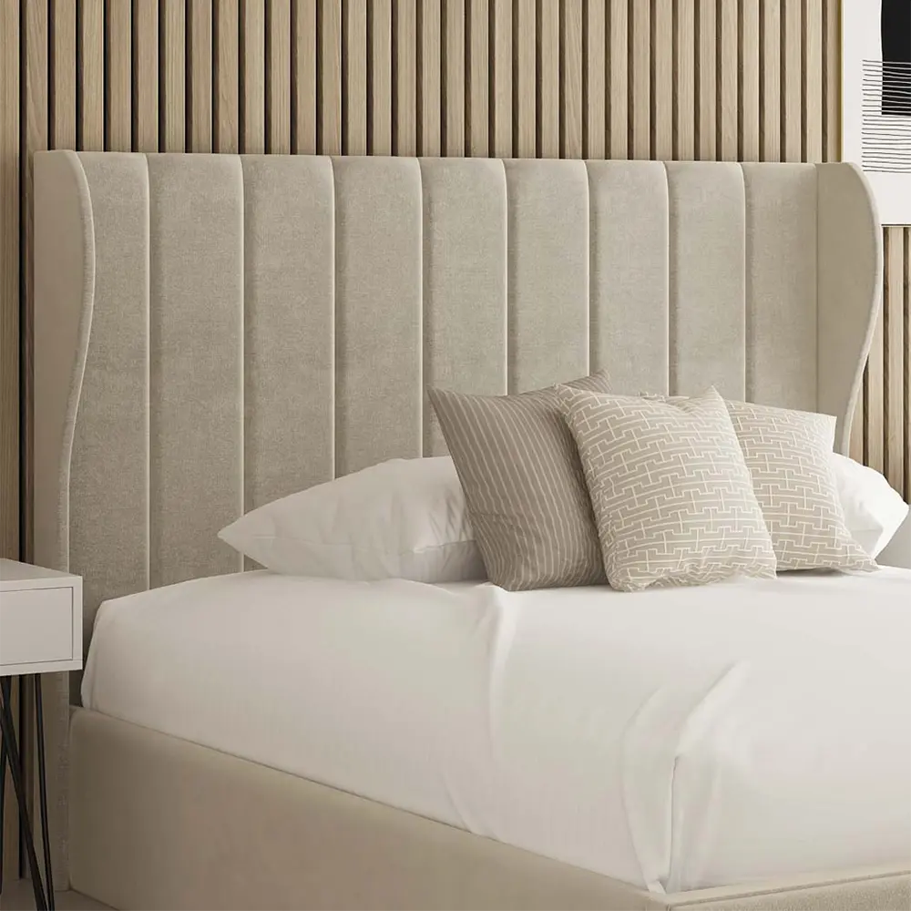 Beige upholstered headboard with white bedding and patterned pillows in a bedroom setting.