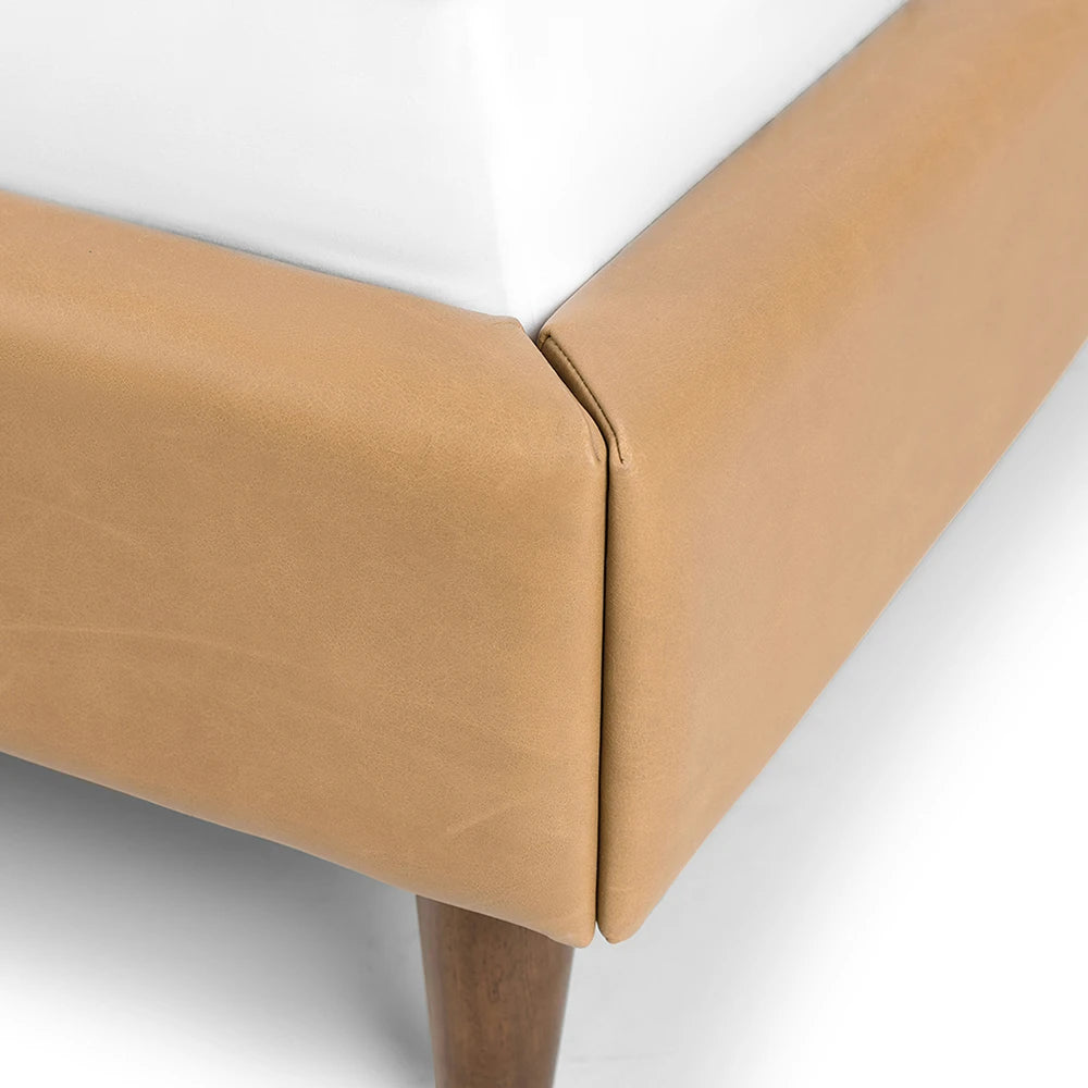 Close-up of a brown upholstered chair corner on a white background