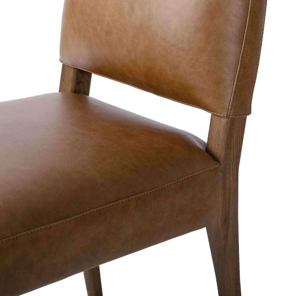 Brown leather chair with wooden frame in living room.