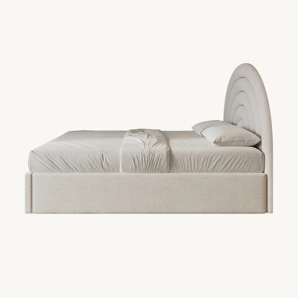 Beige upholstered bed with a curved headboard on a white background