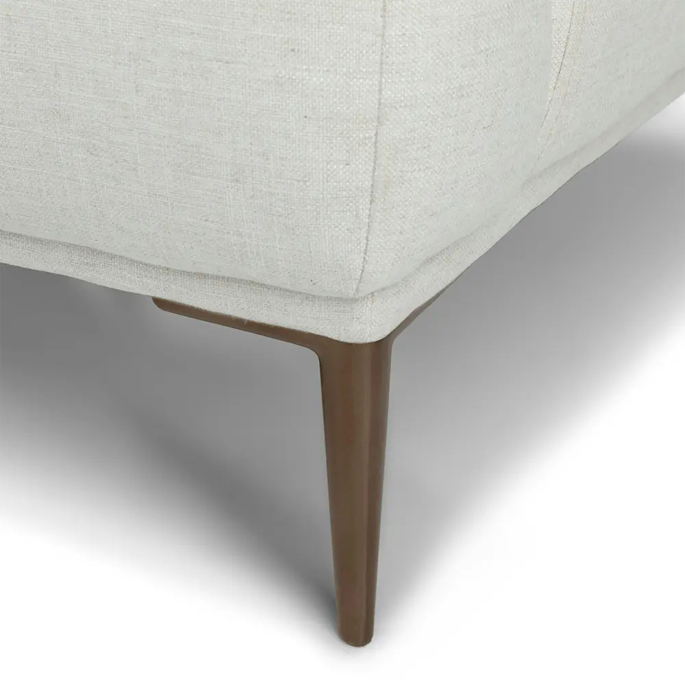 Close-up of a sofa with a wooden leg on a white background