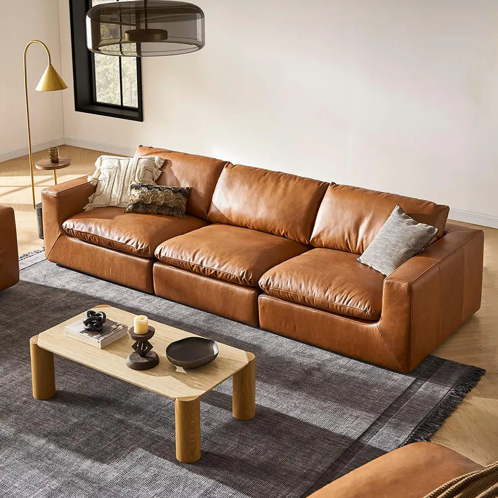 Brown leather sofa in a living room with a coffee table.