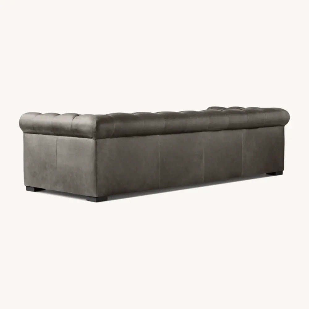 Gray tufted sofa backside with sturdy frame in lounge setting.