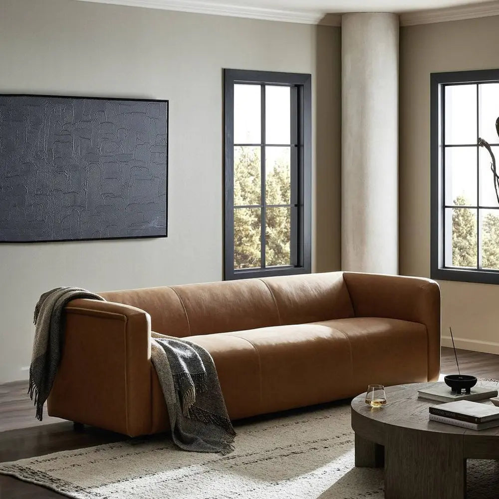Brown leather sofa in a modern living room with a coffee table.
