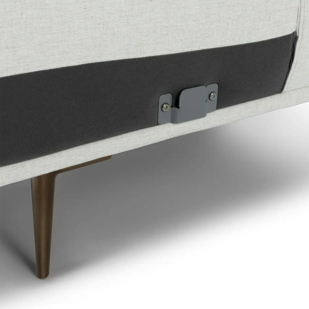 Close-up of a sofa with a black cushion and wooden leg on a light gray background