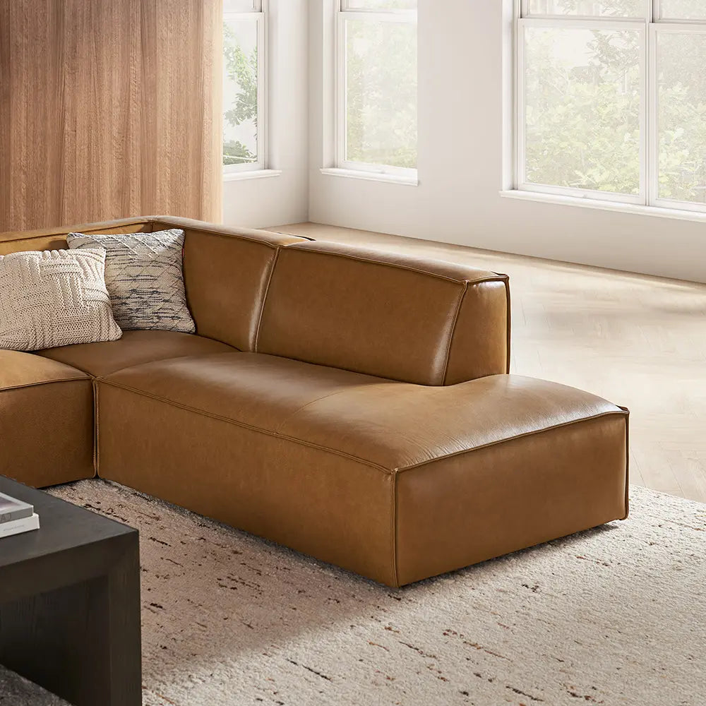 Brown leather sectional sofa in a living room with sleeky profile.