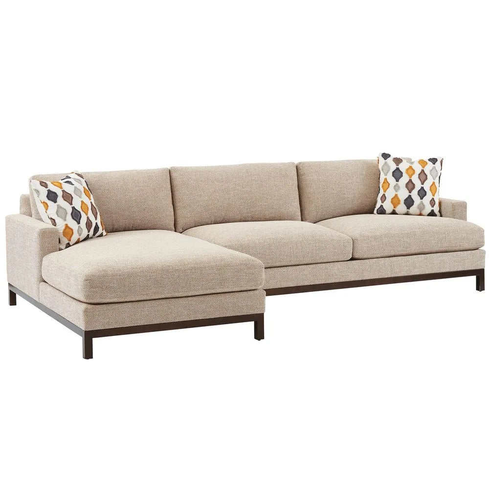 Beige sectional sofa with patterned cushions on a white background