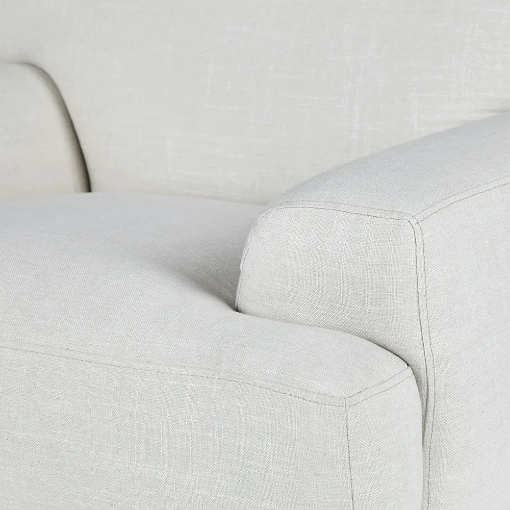 Close-up of a light gray armchair with a soft texture.