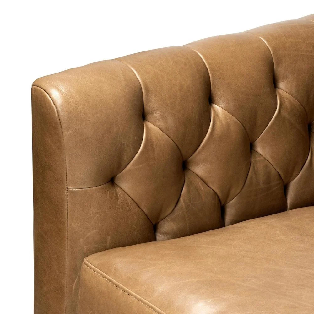 Close-up of a brown leather sofa with tufted backrest