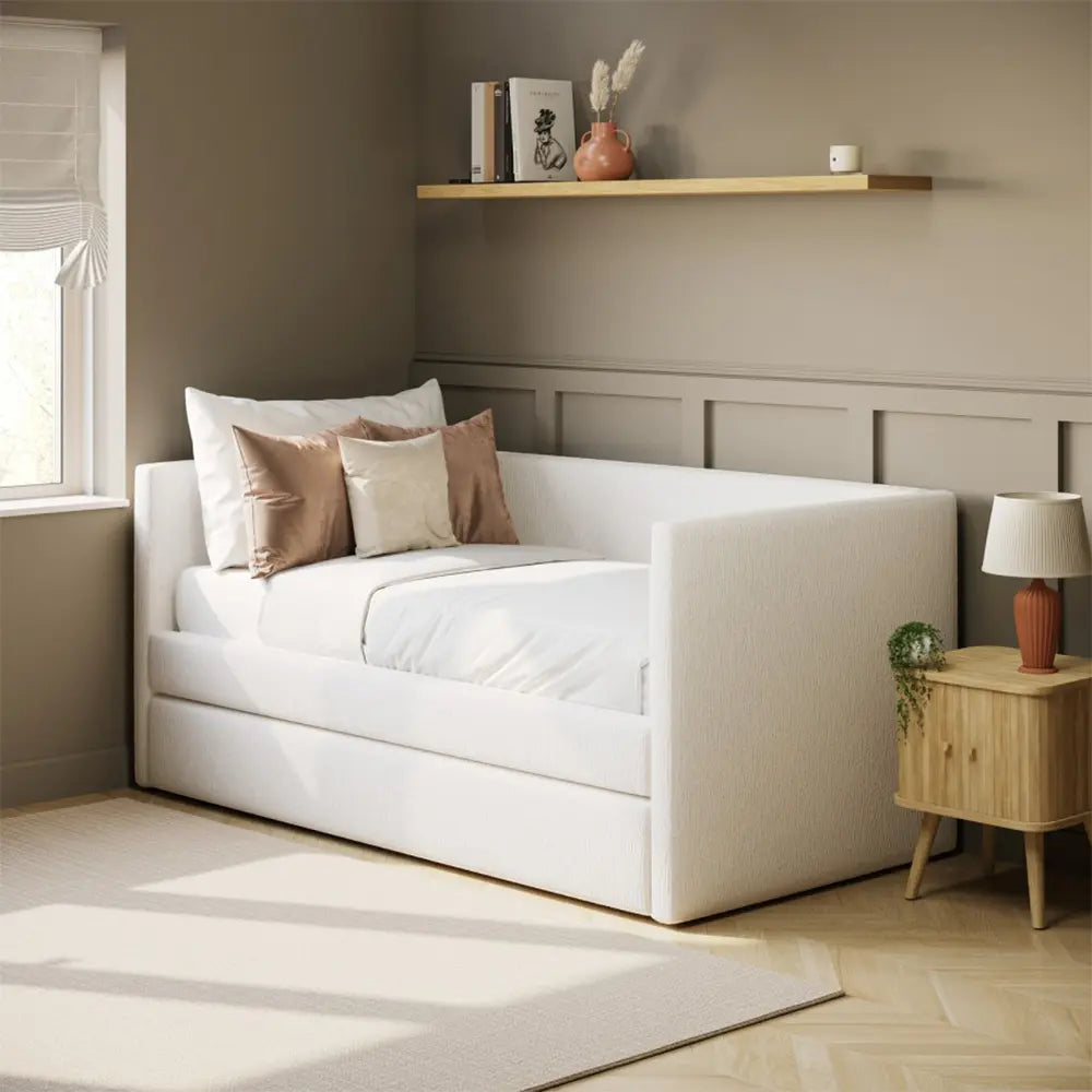 Stylish white sofa bed in a room with a wooden shelf and lamp.