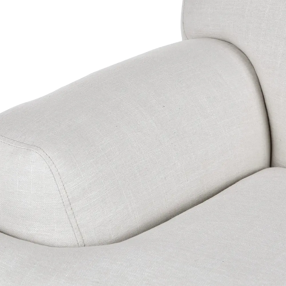 Close-up of a light gray armchair with visible stitching in living room.