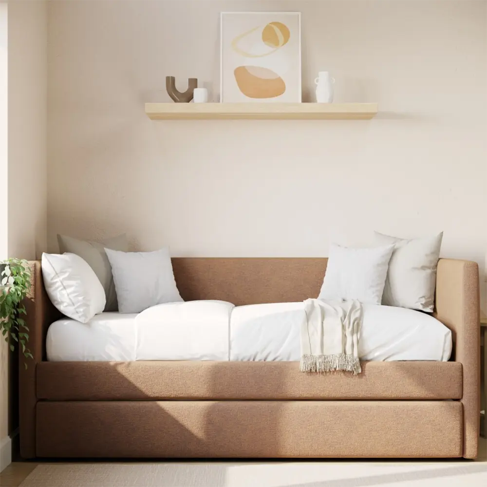 Beige sofa bed with white bedding in a room with a shelf and decor.
