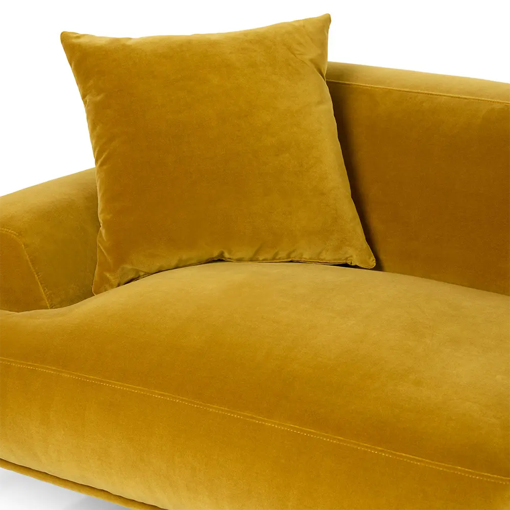 Yellow velvet sofa with a matching pillow on a white background