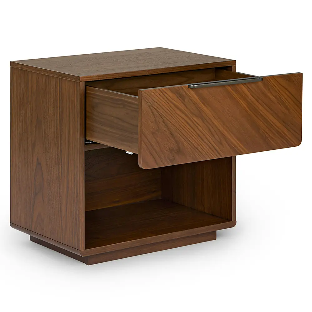 Wooden nightstand with a drawer and sleek profile in bedroom setting.