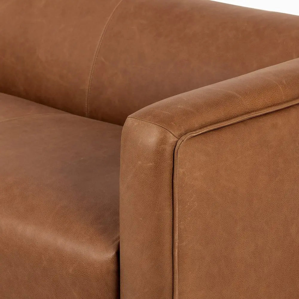 Close-up of a brown leather sofa corner in modern lounge setting.