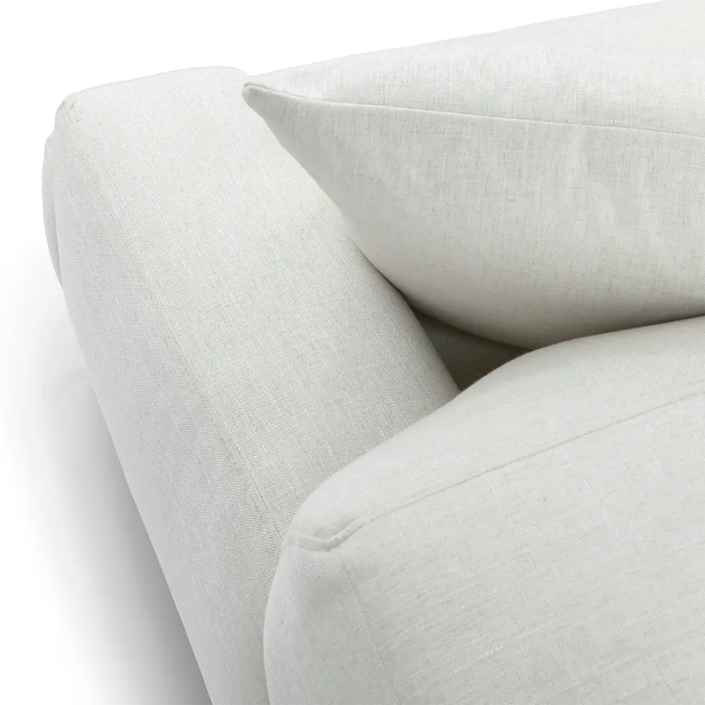 Close-up of a light gray sofa with a pillow on a white background