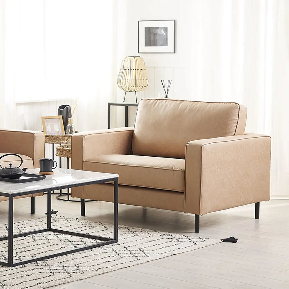Beige sofa in a modern living room with a coffee table and decorative items.
